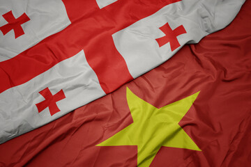 waving colorful flag of vietnam and national flag of georgia.