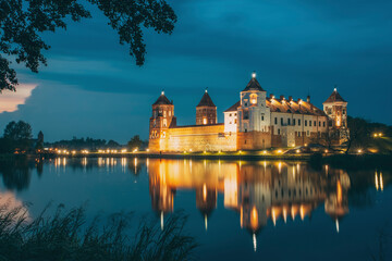 Plakat Mir, Belarus. Night Scenic View Of Mir Castle In Evening Illumination With Glow Reflections On Lake Water. UNESCO Heritage Site. Famous Landmark