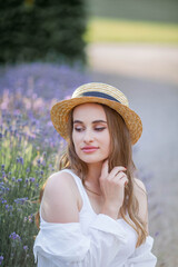 Beautiful young woman in the sunset light. Portrait of a beautiful woman in blooming lavender. Summer.