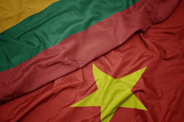 waving colorful flag of vietnam and national flag of lithuania.