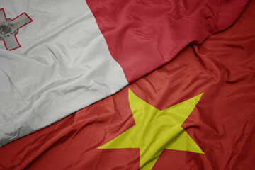 waving colorful flag of vietnam and national flag of malta.