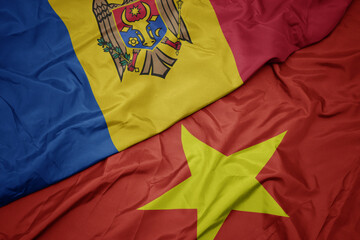 waving colorful flag of vietnam and national flag of moldova.