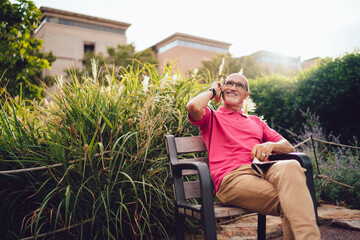 Cheerful senior man talking on phone in park