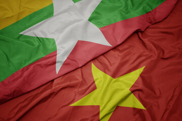 waving colorful flag of vietnam and national flag of myanmar.
