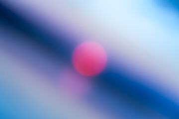 abstract defocused blue background with bright pink spot in the center.
