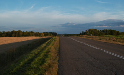 Fototapeta na wymiar Panorama of an asphalt road in the countryside at sunset. Photo.