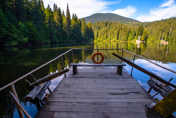 High-altitude lake Synevir .Tray on the water blue sky clear water green forest.