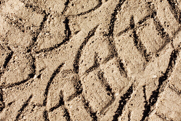 Tyre mark background. Tire track shape. Trail lines on dry yellow sand pattern.