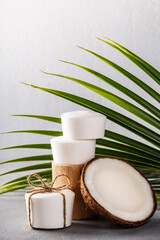 Fototapeta na wymiar Handmade coconut oil soap white color with palm leaf on grey concrete background.