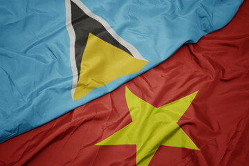 waving colorful flag of vietnam and national flag of saint lucia.