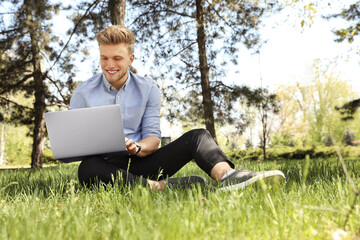 Young man working on laptop in park