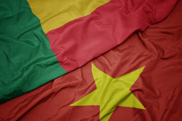 waving colorful flag of vietnam and national flag of benin.