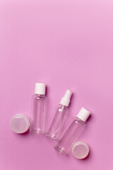 Cosmetic bottles and jars on a pink background