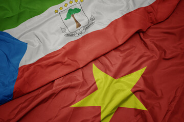 waving colorful flag of vietnam and national flag of equatorial guinea.