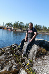 Man on stone island in Ladoga skerries