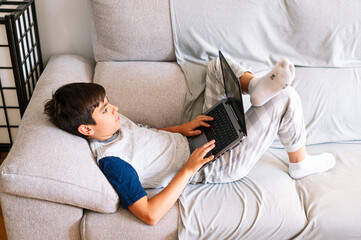 11 year old boy with laptop at home