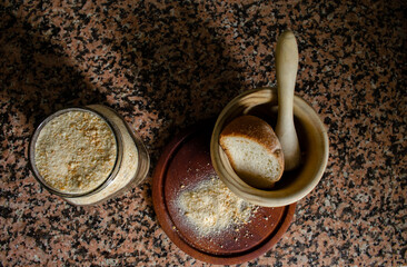 Handmade breadcrumbs with mortar and a glass jar on marble background
