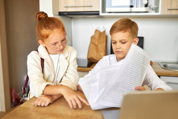 friendly kids couple behave themselves as adults, solve work problems together, look at laptop and documents, checking bills, making purchase online, freelance. children, people concept