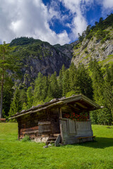 kleine Hütte auf einer grünen Wiese vor bewölktem Himmel
