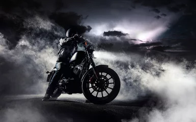 Fototapete Motorrad Detail eines leistungsstarken Motorrad-Choppers mit Mannfahrer bei Nacht.