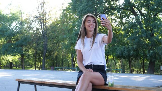 the girl video blogger communicates with subscribers via the phone, shows the surroundings around her, and with her face shows hypocrisy and irritation, smiling only when the camera is filming her