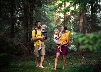 Family with small children walking barefoot outdoors in summer nature.