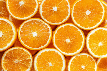 Closeup top view of pattern, laid out slices of juicy oranges on background. Summer tropical citrus fruit for preparing cool freshly squeezed juices, cocktails, drinks, beverages concept.