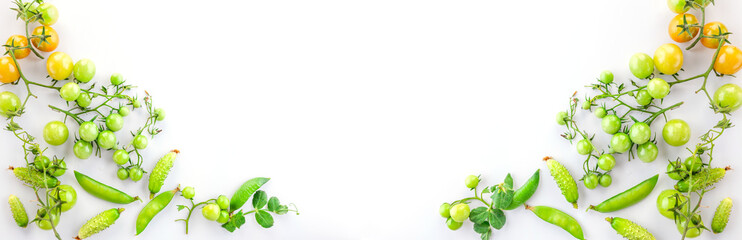 Fresh green vegetables on a white background. Background of plant food. Pattern of tomatoes, gherkins, lettuce and green peas. Flat lay