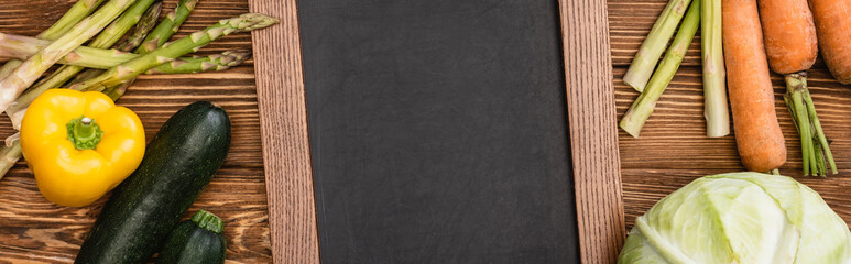top view of fresh ripe vegetables and empty chalkboard on wooden background, panoramic shot