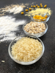 Different types of flour and grains on a dark textured background