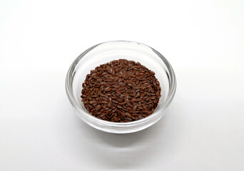 Brown linseed in a transparent bowl, detailed view in a photo box