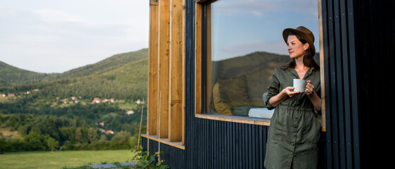 Fototapeta na wymiar Young woman outdoors, weekend away in container house in countryside.