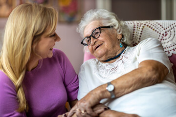 Young woman spending time with her elderly grandmother at home
