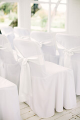 White chairs as part of decor for wedding or festive ceremony. Wedding concept. 