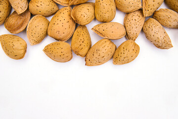 Fototapeta na wymiar Inshell almonds on a white background. Almonds are arranged in a pile.