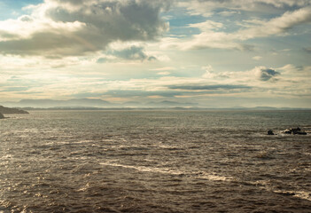 Obraz premium rocky sea beach with crashing waves at morning from flat angle