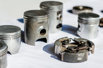 Motorcycle spare parts are placed on a white table to study and design a shape for higher performance and fuel efficiency by engine engineers. Engineers put parts of the motorcycle engine on the table