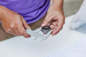 Motorcycle spare parts are placed on a white table to study and design a shape for higher performance and fuel efficiency by engine engineers. Engineers put parts of the motorcycle engine on the table