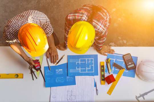 The engineer is giving advice and consulting with the designer to find out the construction site where the engineer will have to construct the project. Consultation between engineers and designers