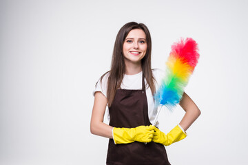 Young woman wearing yellow rubber gloves for hands protection holding colorful duster while cleaning room isolated over white background