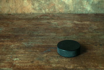 Ice hockey puck on a retro wooden background