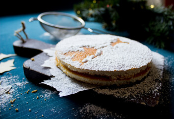 New year's holiday cake on a wooden Board with powdered sugar. Cooking. Templates for baking. High...