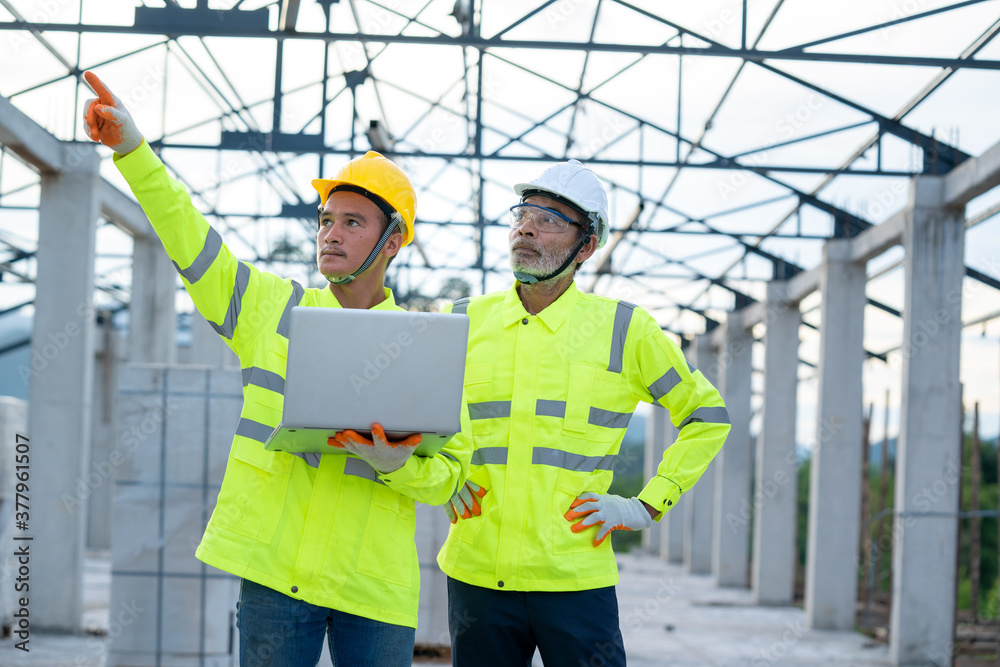 Poster engineer using laptop working on building site,construction concept.