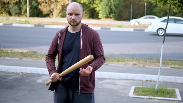 Racketeer bully threatens with a bat by the roadside highway. Theft, Slow motion
