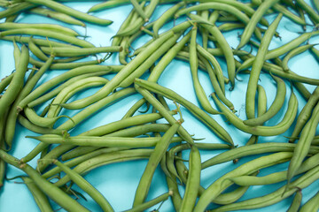 Raw green beans on a colored background