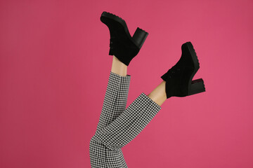 Woman wearing stylish boots on pink background, closeup