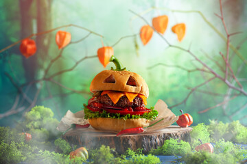 Halloween party burger in shape of scary pumpkin   on natural wooden board. Halloween food concept.