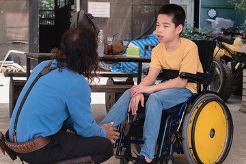 Disabled child on wheelchair is playing,learning and exercise in the outdoor horse farm,Nature background,Lifestyle of special child,Life in the education age of children,Happy disability kid concept.