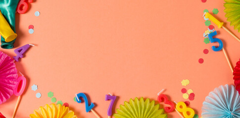 Birthday party background of living coral color. Party accessories on orange