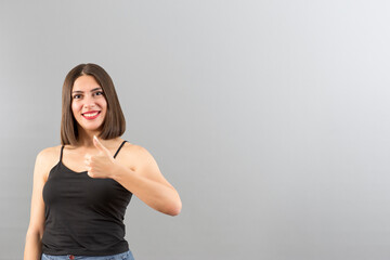 Attractive Turkish woman portrait in positive mood. She is gesturing thumbs up.